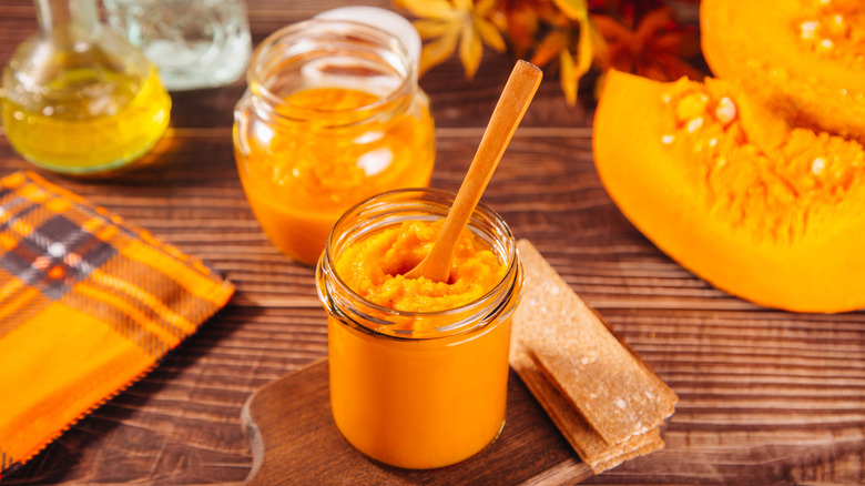 A jar of pumpkin pure with fall decor in the background
