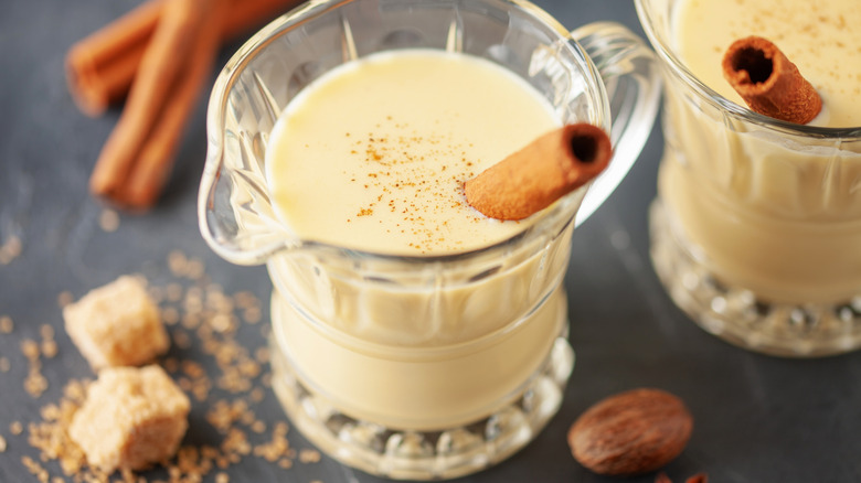 Overhead view of glasses of eggnog with cinnamon sticks