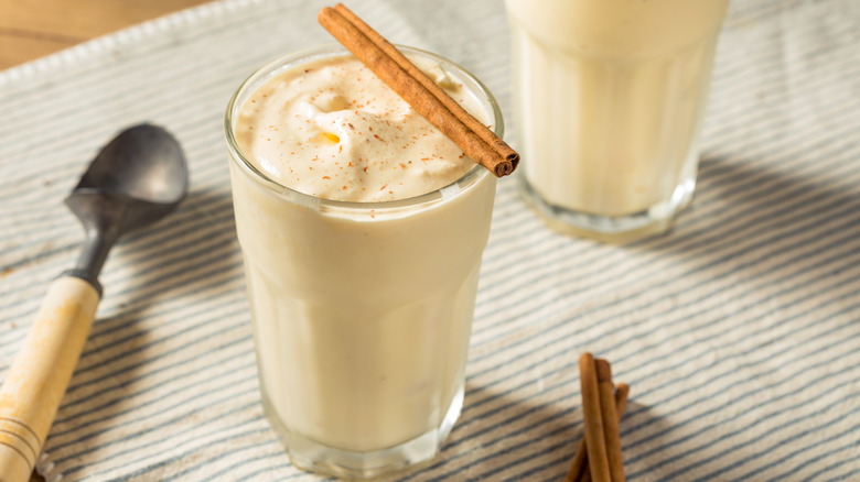 Close-up of eggnog milkshake in a glass with cinnamon stick