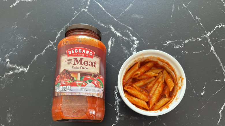 Bottle of Reggano Meat Pasta Sauce over penne