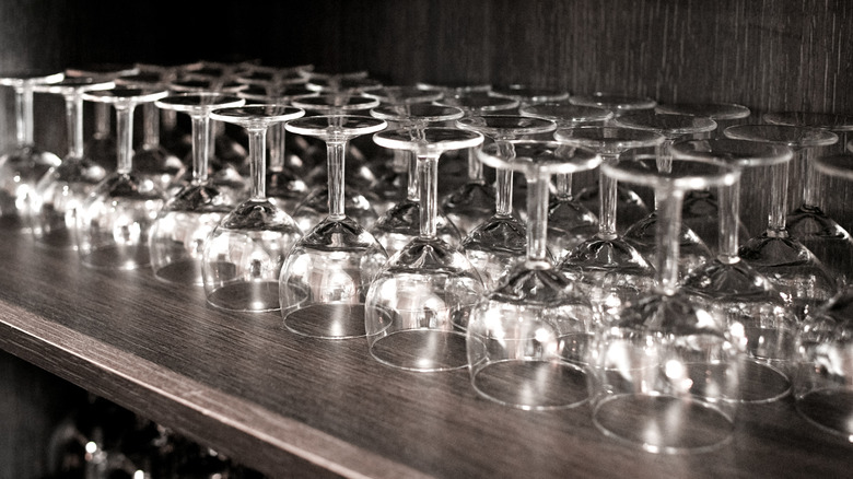 A shelf of glasses stacked upside down