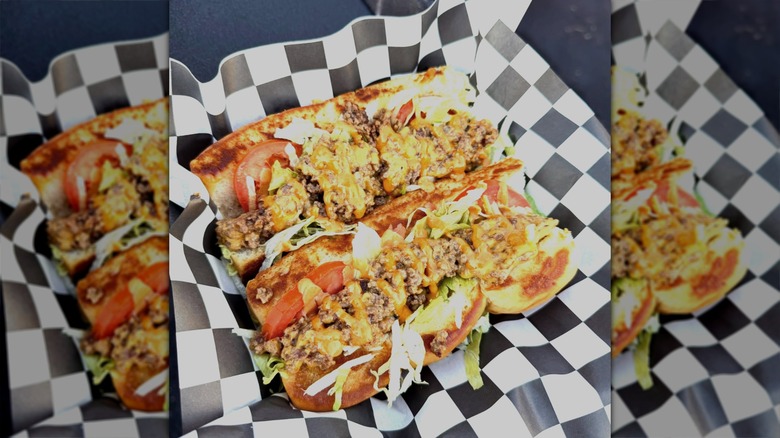 chopped beef hot dogs on black and white checkered paper.