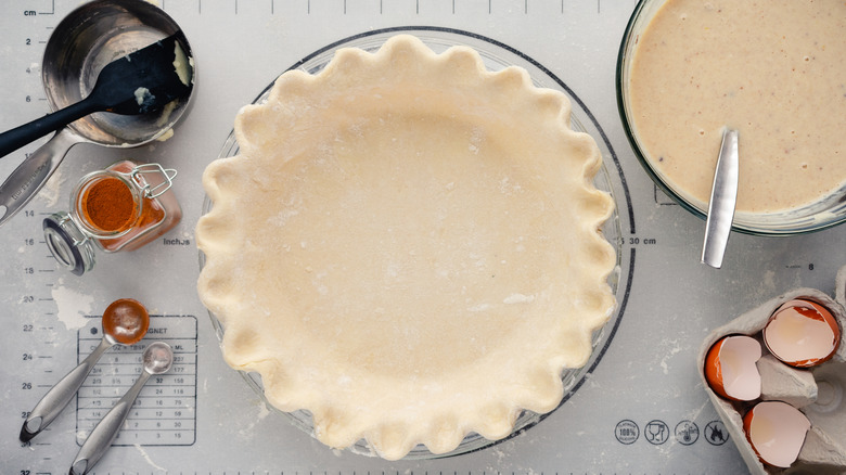 empty pie crust on baking mat with ingredients