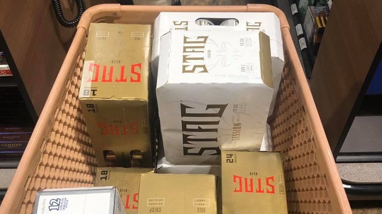 A tan shopping cart filled with boxes of Stag beer