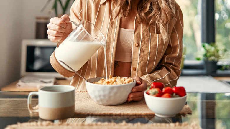 someone pouring milk into a bowl of ice cream