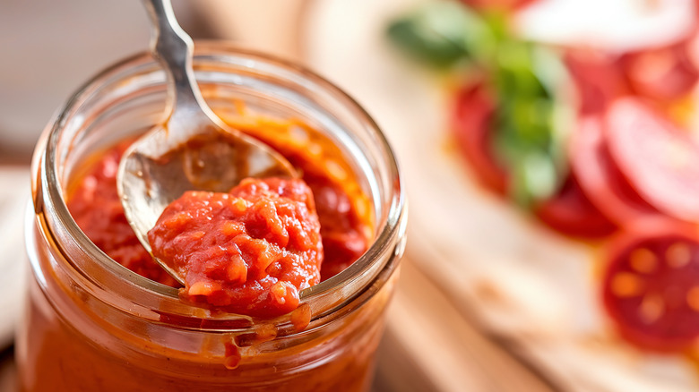 jar of pizza sauce in front of pizza