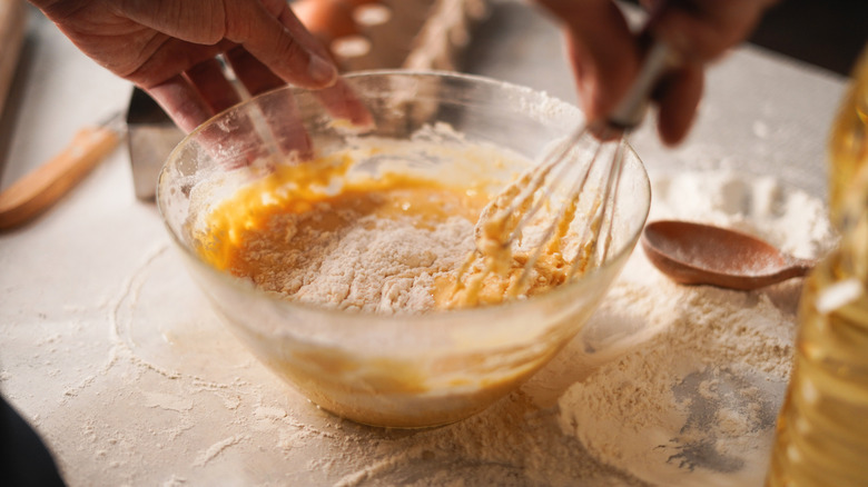 Mixing flour into batter for a baked good