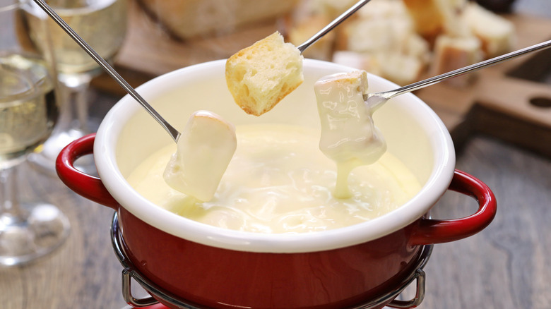 Bread cubes on forks being dipped into a pot of cheese fondue