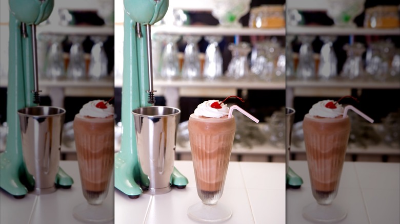 A milkshake mixer next to a chocolate shake