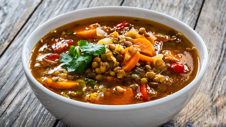 Vegetable soup made with lentils in a white bowl