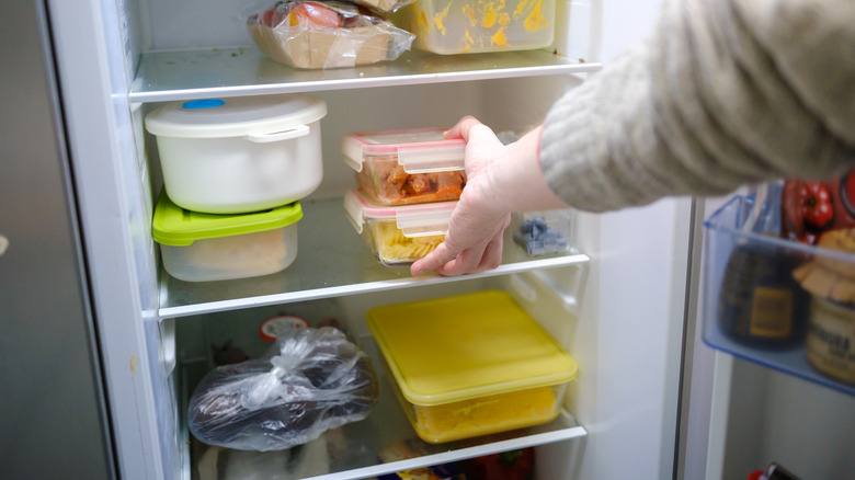 Foodie taking leftovers containers out of the fridge