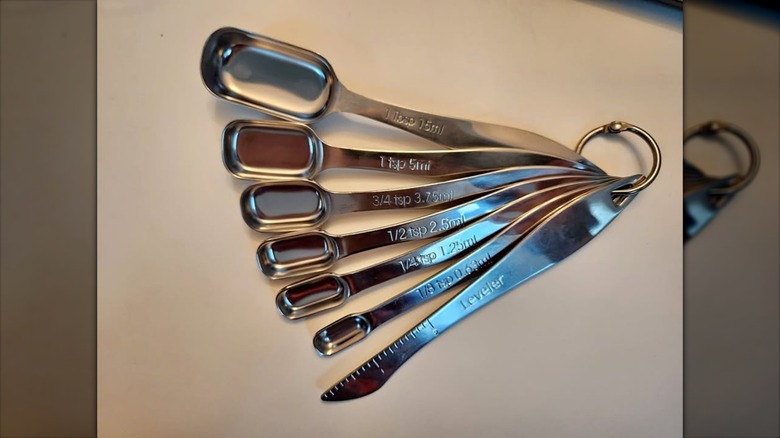 Stainless steel rectangular measuring spoons on a flat surface