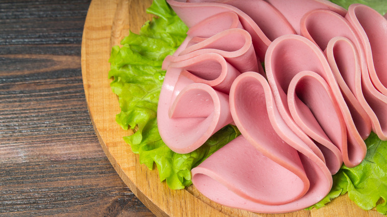 bologna on wood board with lettuce