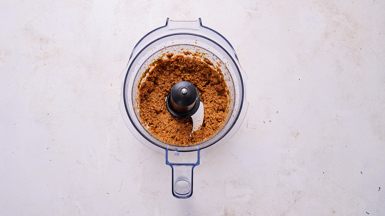 red pesto and olive oil in a food processor