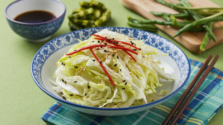 A blue and white bowl containing yamitsuki cabbage with sesame seeds and sauce