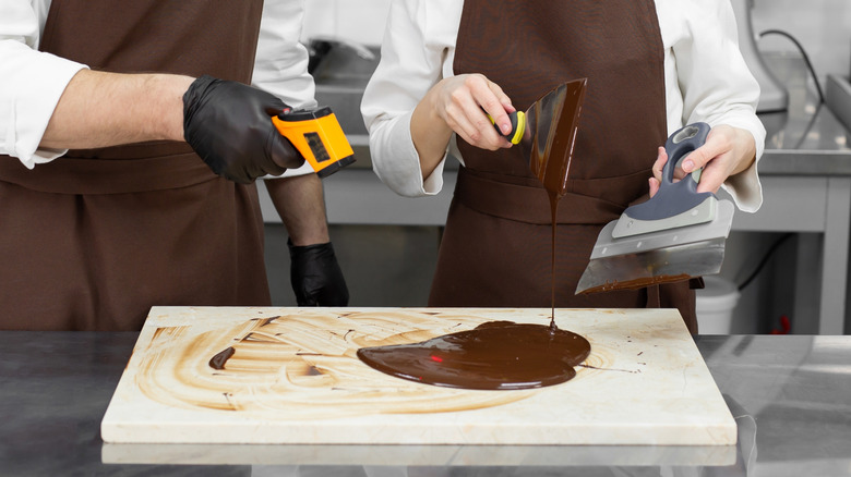 Chefs measuring chocolate infrared thermometer