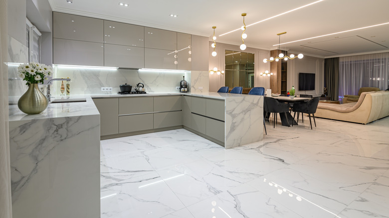 A kitchen in mostly white and gray marble including the countertops on the floor