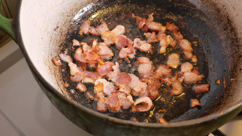 small bacon pieces frying in a large pot