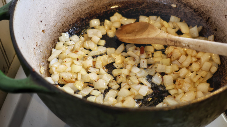 a pot of cooked diced onion with a wooden spoon in it