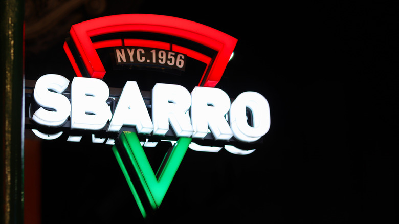 The new Sbarro logo shines in a neon sign outside of a location.