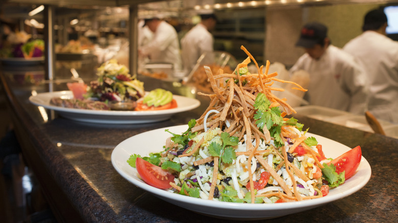 Salad and other dishes on the counter in the Cheesecake Factory kitchen