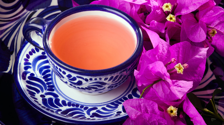 pink tea in Mexican saucer and cup with bougainvillea flowers