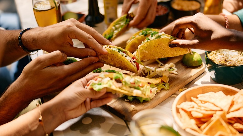 Aerial views of hands holding tacos at a Mexican restaurant