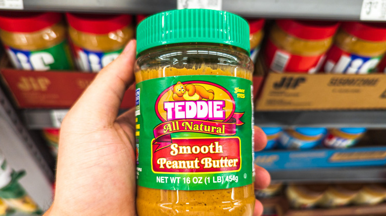 shopper holding Teddie peanut butter