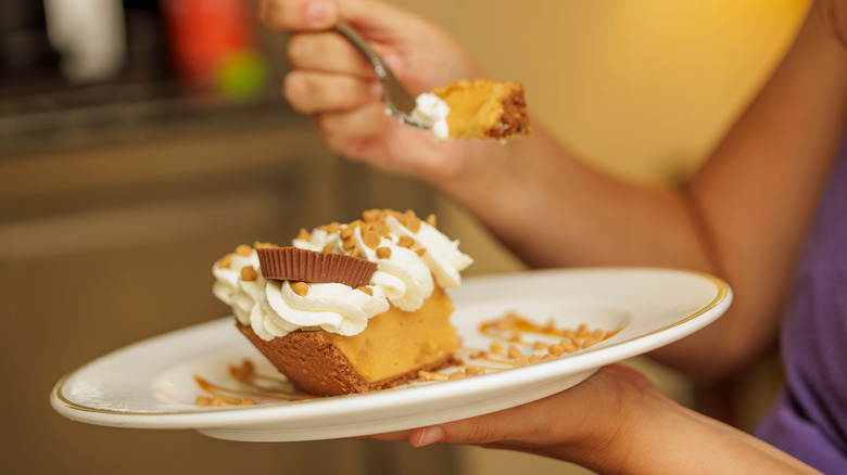 Someone eats a slice of peanut butter pie