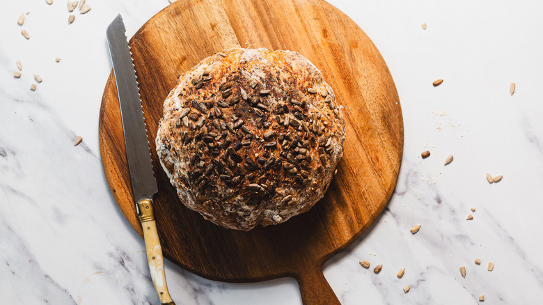 Bread loaf on cutting board beside knife