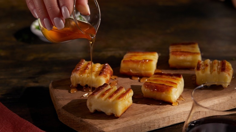 Fogo de Chão's grilled cheese appetizer being drizzled with honey