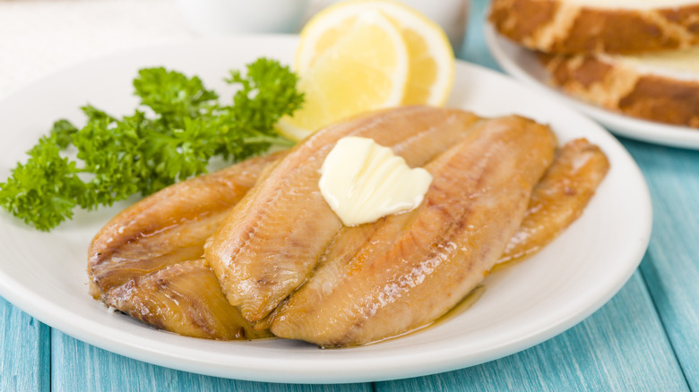 Smoked kippers plated with butter and lemon