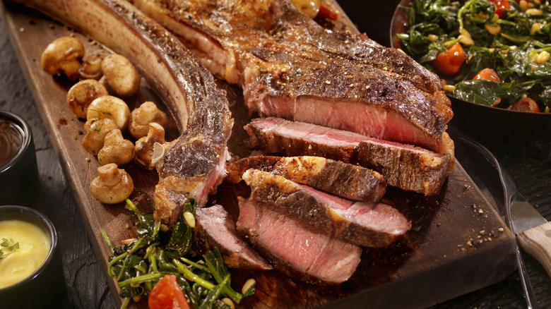 Generous steak serving on a wood slab