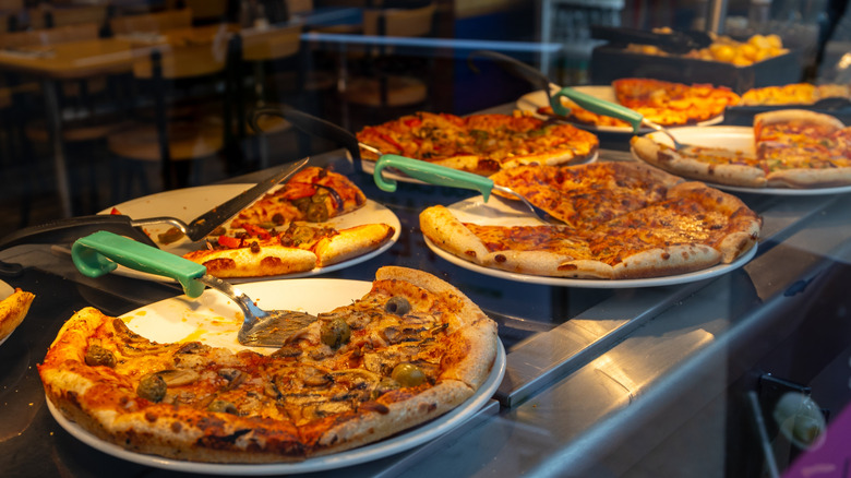 an array of pizzas at a buffet
