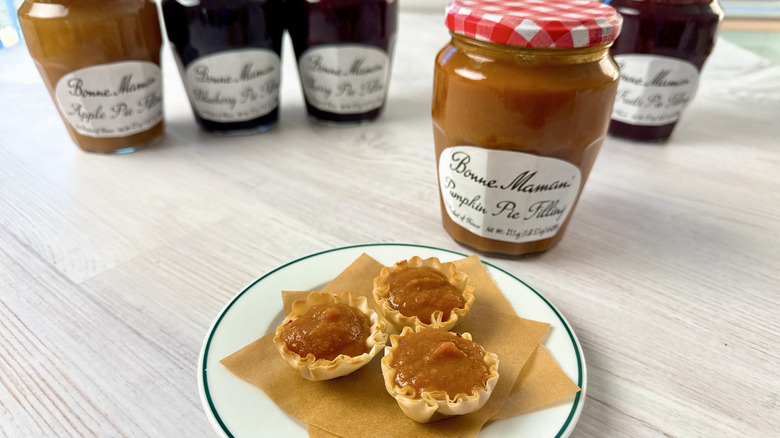 Plate with mini pumpkin pies in front of Bonne Maman pie filling jars