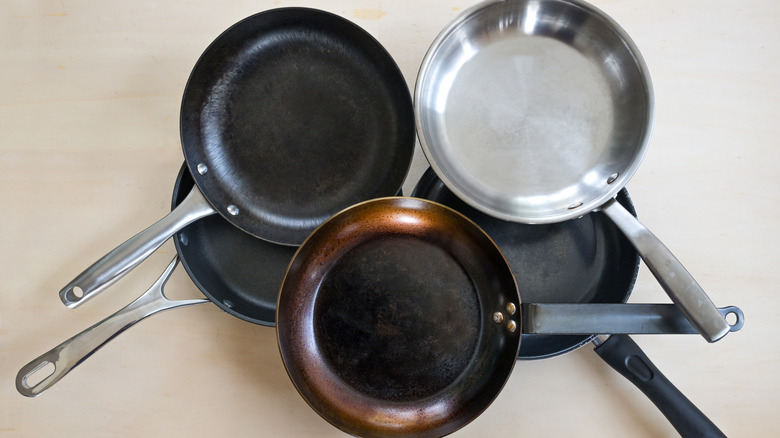 Stack of a variety of frying pans made from different materials