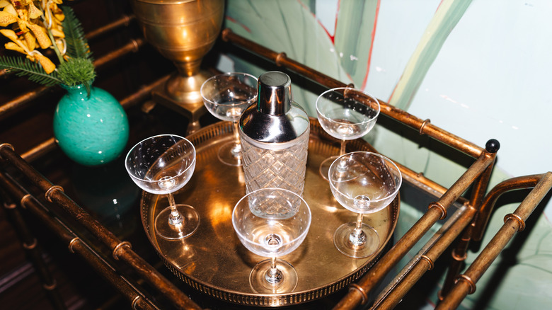 Mid-century cocktail tray and barware on teak bar cart