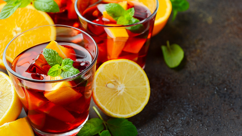 Two glasses of a lemon iced tea cocktail topped with mint