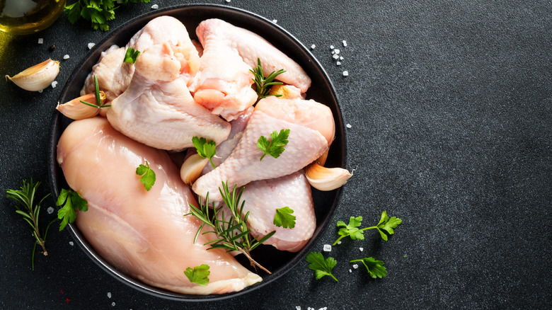Plate with a broken-down whole chicken sprinkled with fresh herbs