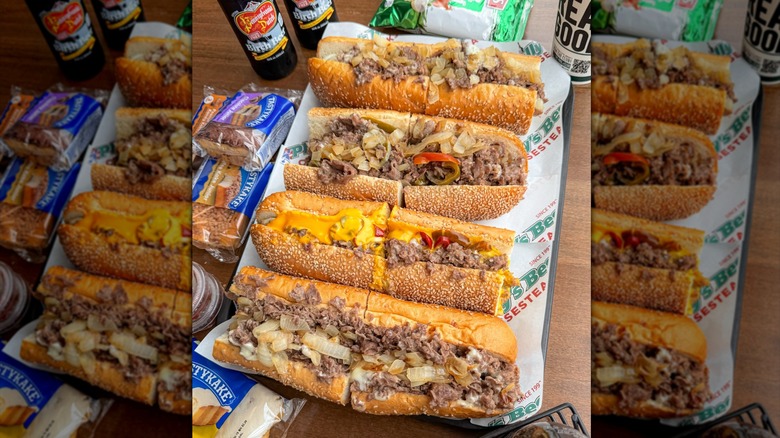 Assortment of cheesesteaks from Philly's Best beside packaged snacks and drinks