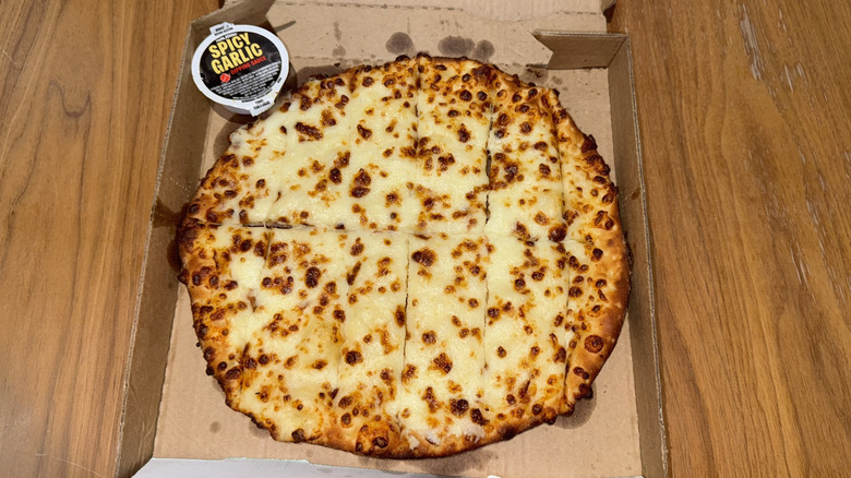 Papa John's cheesy bread in cardboard box with spicy garlic dipping sauce
