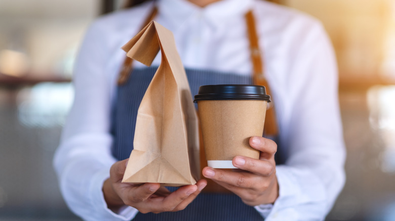 barista serves to-go coffee and pastry in bag