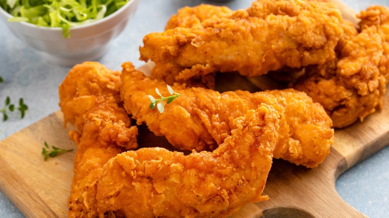 Chicken tenders on a wooden board