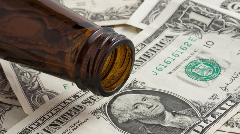 Empty brown beer bottle on American $1 bill
