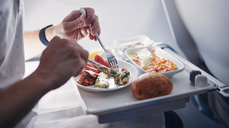 Man eating meal on airplane