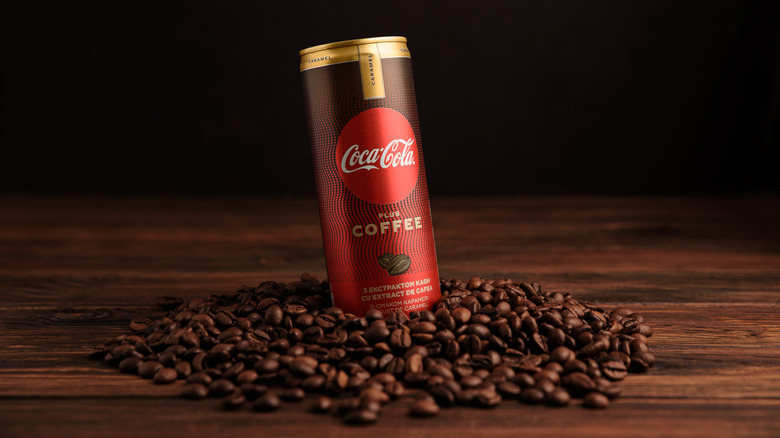 a can of Coca-Cola Plus Coffee sitting atop a mound of coffee beans
