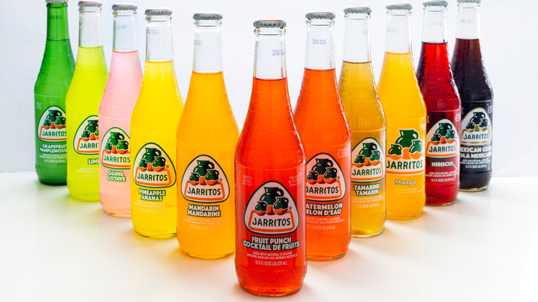 many flavors of Jarritos soda lined up in a v shape against a white background