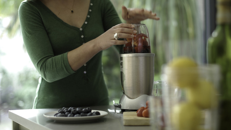A woman using a Nutribullet blender