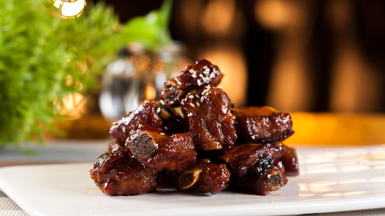 A pile of sticky braised ribs on a plate
