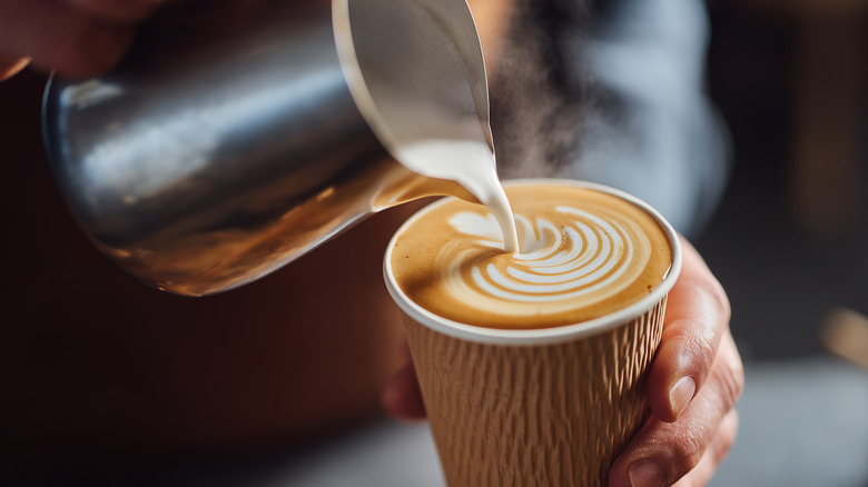 A barista pouring a latte